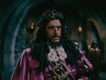 Movie still from “The Black Swan” (1942), directed by Henry King – A person with long hair and a beard; Medium shot, Over the shoulder angle