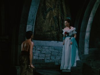 Movie still from “The Black Swan” (1942), directed by Henry King – A man and a woman dressed in medieval garb in front of a stone wall; Wide shot, High angle