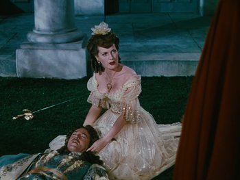 Movie still from “The Black Swan” (1942), directed by Henry King – A woman sitting on the ground next to a man; Medium shot, High angle