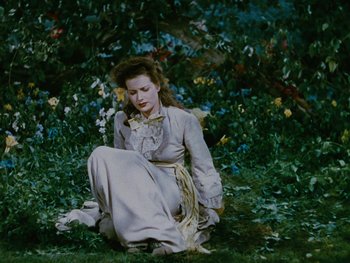 Movie still from “The Black Swan” (1942), directed by Henry King – A woman sitting on the ground in the grass; Wide shot, High angle