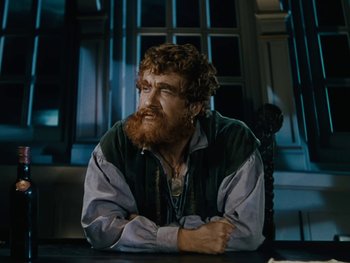 Movie still from “The Black Swan” (1942), directed by Henry King – A man with a red beard sitting at a table; Close Up shot, Over the shoulder angle