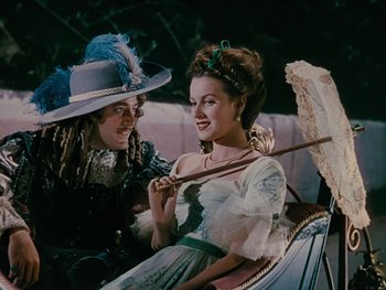 Movie still from “The Black Swan” (1942), directed by Henry King – A man and a woman sitting in a carriage holding an umbrella; Medium shot, High angle