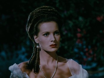 Movie still from “The Black Swan” (1942), directed by Henry King – A woman in a white dress and a pearl necklace; Close Up shot, Over the shoulder angle