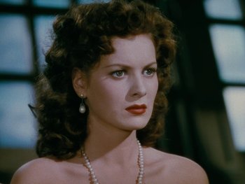 Movie still from “The Black Swan” (1942), directed by Henry King – A beautiful woman with long curly hair wearing a necklace; Close Up shot, Low angle
