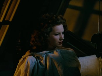 Movie still from “The Black Swan” (1942), directed by Henry King – A beautiful woman sitting on top of a couch; Close Up shot, High angle