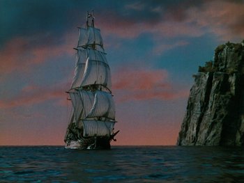 Movie still from “The Black Swan” (1942), directed by Henry King – A large sail boat in the middle of the ocean at sunset; Extreme Wide shot, Low angle
