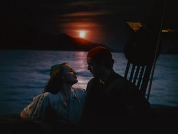 Movie still from “The Black Swan” (1942), directed by Henry King – A man and a woman sitting next to each other on a boat; Wide shot, High angle