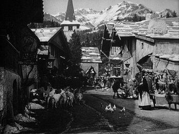 Movie still from “The Blue Bird” (1940), directed by Walter Lang – A black and white photo of a village with sheep and chickens; Wide shot, High angle