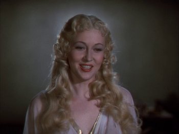 Movie still from “The Blue Bird” (1940), directed by Walter Lang – A woman with long blonde hair smiling for the camera; Close Up shot, Low angle