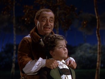 Movie still from “The Blue Bird” (1940), directed by Walter Lang – A man and a boy are standing next to each other; Medium shot, Low angle