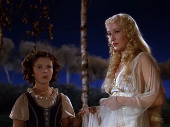 Movie still from “The Blue Bird” (1940), directed by Walter Lang – A woman in a white dress standing next to a young girl; Medium shot, Low angle