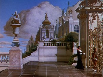 Movie still from “The Blue Bird” (1940), directed by Walter Lang – A woman in a long black dress walking down a hall way; Extreme Wide shot, Low angle