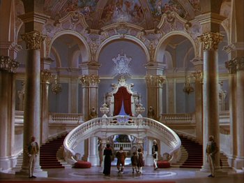Movie still from “The Blue Bird” (1940), directed by Walter Lang – A group of people standing in front of an ornate staircase; Extreme Wide shot, High angle