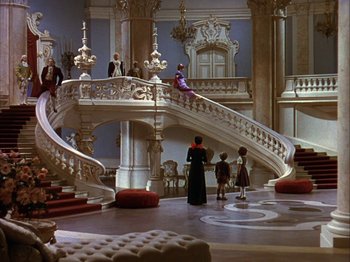 Movie still from “The Blue Bird” (1940), directed by Walter Lang – A group of people standing on a staircase in a room; Extreme Wide shot, High angle
