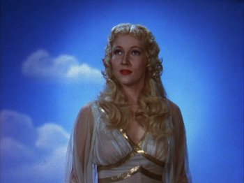 Movie still from “The Blue Bird” (1940), directed by Walter Lang – A woman with long blonde hair wearing a white and gold dress; Close Up shot, Low angle