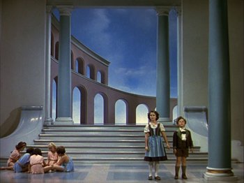 Movie still from “The Blue Bird” (1940), directed by Walter Lang – Two children and an older woman in front of a painting; Extreme Wide shot, Low angle