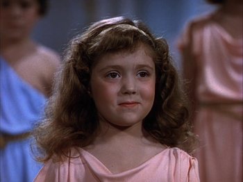 Movie still from “The Blue Bird” (1940), directed by Walter Lang – A young girl in a pink dress with long brown hair; Close Up shot, High angle