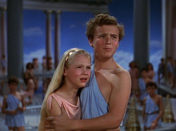 Movie still from “The Blue Bird” (1940), directed by Walter Lang – A man and a woman hugging each other in front of a crowd; Medium shot, High angle