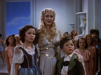 Movie still from “The Blue Bird” (1940), directed by Walter Lang – A woman and two children standing next to each other; Medium shot, Low angle