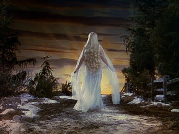 Movie still from “The Blue Bird” (1940), directed by Walter Lang – A woman dressed in white walking in the snow; Wide shot, Low angle