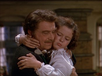 Movie still from “The Blue Bird” (1940), directed by Walter Lang – A man and a little girl hugging each other; Medium shot, High angle