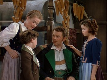 Movie still from “The Blue Bird” (1940), directed by Walter Lang – A group of people standing next to each other in a room; Medium shot, Over the shoulder angle