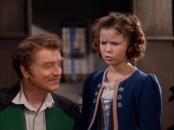 Movie still from “The Blue Bird” (1940), directed by Walter Lang – A man and a woman standing next to each other; Medium shot, Over the shoulder angle