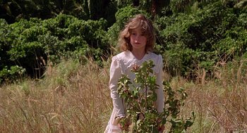 Movie still from “The Blue Lagoon” (1980), directed by Randal Kleiser – A girl in a white dress standing next to a bush; Medium shot, Low angle