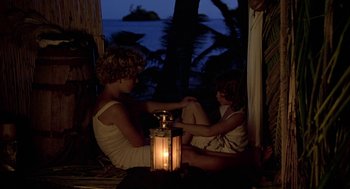 Movie still from “The Blue Lagoon” (1980), directed by Randal Kleiser – A woman and a child sitting next to each other; Wide shot, High angle