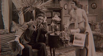 Movie still from “The Blue Lagoon” (1980), directed by Randal Kleiser – An old black and white photo of a man and a woman; Medium shot, Low angle