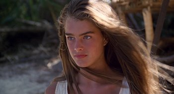 Movie still from “The Blue Lagoon” (1980), directed by Randal Kleiser – A beautiful young woman with long brown hair and blue eyes; Close Up shot, Over the shoulder angle