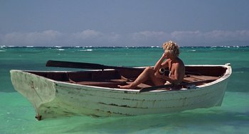 Movie still from “The Blue Lagoon” (1980), directed by Randal Kleiser – A woman sitting in a boat in the ocean; Wide shot, High angle