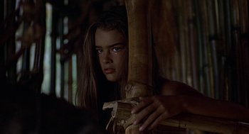 Movie still from “The Blue Lagoon” (1980), directed by Randal Kleiser – A young girl leaning against a bamboo pole; Close Up shot, Over the shoulder angle