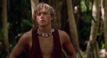 Movie still from “The Blue Lagoon” (1980), directed by Randal Kleiser – A young man wearing a necklace in the woods; Close Up shot, Low angle