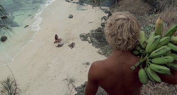Movie still from “The Blue Lagoon” (1980), directed by Randal Kleiser – A man standing on the beach looking at the water; Wide shot, Overhead angle