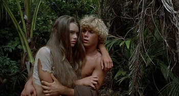 Movie still from “The Blue Lagoon” (1980), directed by Randal Kleiser – A man and a woman embracing each other in the woods; Medium shot, High angle