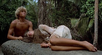 Movie still from “The Blue Lagoon” (1980), directed by Randal Kleiser – A man and a woman laying on the ground in the woods; Wide shot, Overhead angle