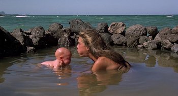 Movie still from “The Blue Lagoon” (1980), directed by Randal Kleiser – A woman and a baby in the water in front of the ocean; Medium shot, High angle