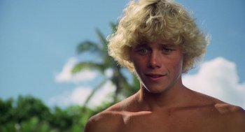 Movie still from “The Blue Lagoon” (1980), directed by Randal Kleiser – A young man with blonde hair is posing for a picture; Close Up shot, Low angle