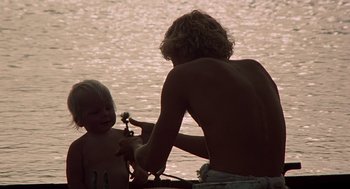 Movie still from “The Blue Lagoon” (1980), directed by Randal Kleiser – A young man and a child in a body of water; Medium shot, Over the shoulder angle