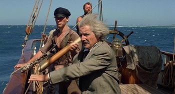 Movie still from “The Blue Lagoon” (1980), directed by Randal Kleiser – A man on a boat holding a baseball bat; Medium shot, Low angle