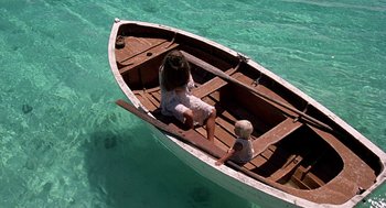 Movie still from “The Blue Lagoon” (1980), directed by Randal Kleiser – A woman and a small child in a small boat in the water; Wide shot, High angle