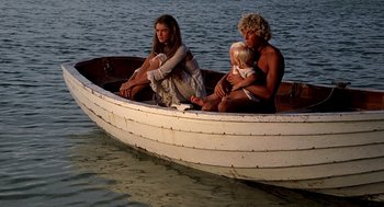 Movie still from “The Blue Lagoon” (1980), directed by Randal Kleiser – A man , woman , and child are in a small boat; Wide shot, High angle