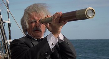 Movie still from “The Blue Lagoon” (1980), directed by Randal Kleiser – An old man with a beard is looking through a telescope; Close Up shot, Low angle