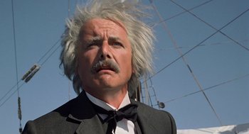 Movie still from “The Blue Lagoon” (1980), directed by Randal Kleiser – An old man with a white beard and a black suit; Close Up shot, Low angle