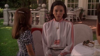 Movie still from “The Bonfire of the Vanities” (1990), directed by Brian De Palma – A woman in a white and pink blouse is talking to a little girl; Medium shot, Over the shoulder angle