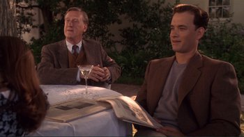 Movie still from “The Bonfire of the Vanities” (1990), directed by Brian De Palma – Two men sitting at a table with a glass of wine; Medium shot, Over the shoulder angle