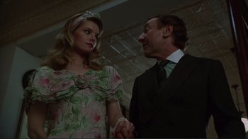 Movie still from “The Bonfire of the Vanities” (1990), directed by Brian De Palma – A man and a woman standing next to each other holding hands; Medium shot, Low angle