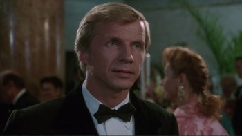 Movie still from “The Bonfire of the Vanities” (1990), directed by Brian De Palma – A person wearing a suit and bow tie; Close Up shot, Low angle