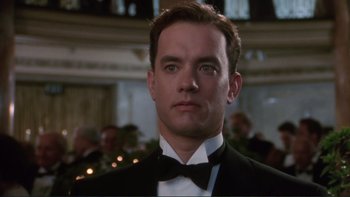 Movie still from “The Bonfire of the Vanities” (1990), directed by Brian De Palma – A man in a suit and bow tie in front of a crowd; Close Up shot, Low angle